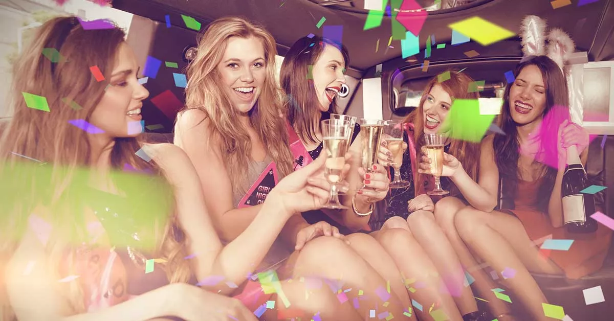 Group of women in the back of a limo celebrating a hens party.